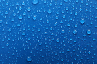 Water drops on blue background, top view