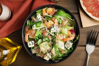 Delicious pomelo salad with shrimps served on wooden table, flat lay