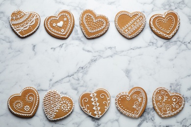 Tasty heart shaped gingerbread cookies on white marble table, flat lay. Space for text