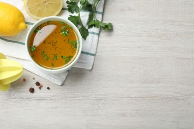 Photo of Bowl of lemon sauce and ingredients on white wooden table, flat lay with space for text. Delicious salad dressing