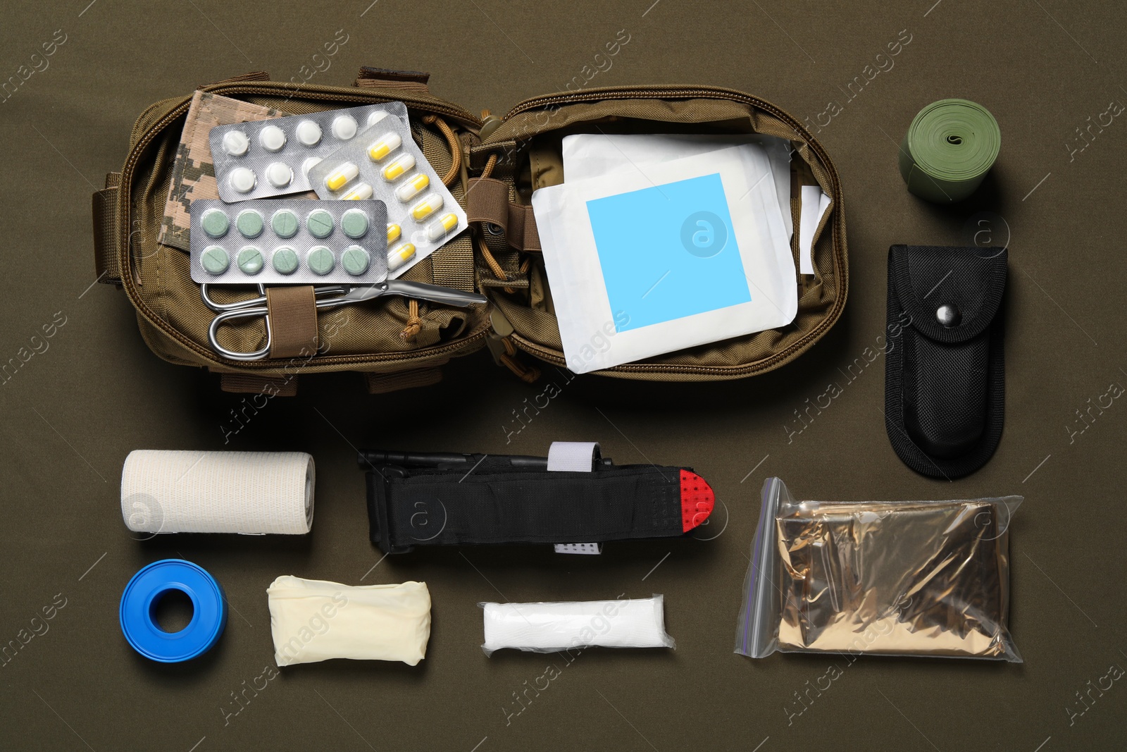 Photo of Flat lay composition with military first aid kit on khaki background