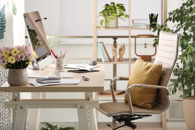 Photo of Comfortable workplace with modern computer and stylish furniture in room. Interior design