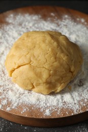 Photo of Making shortcrust pastry. Raw dough and flour on table
