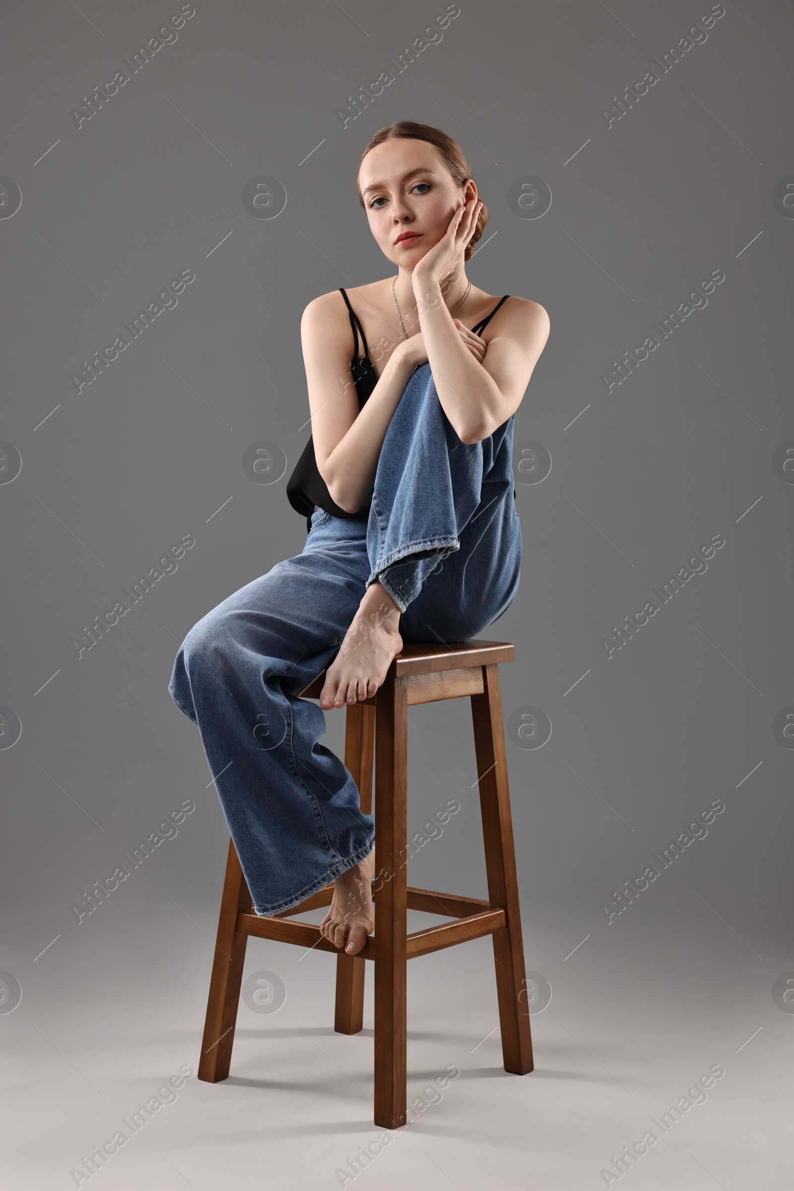 Photo of Fashionable portrait of beautiful young woman on grey background