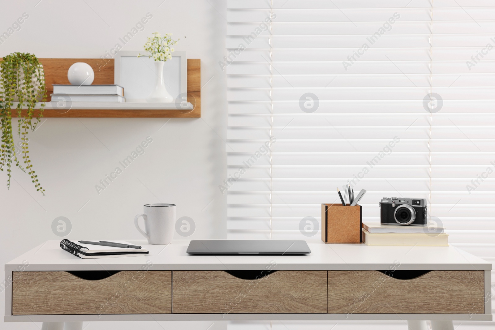 Photo of Home office. Stylish workplace with laptop and stationery on white desk indoors. Space for text