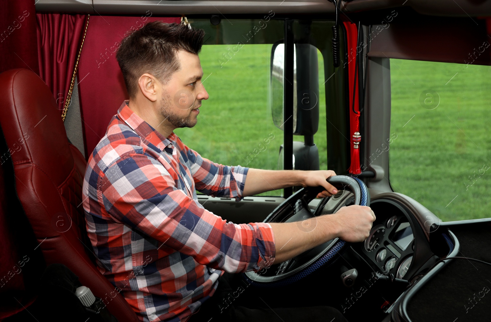 Photo of Professional driver sitting in cab of modern truck