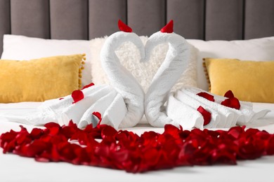 Honeymoon. Swans made with towels and beautiful rose petals on bed