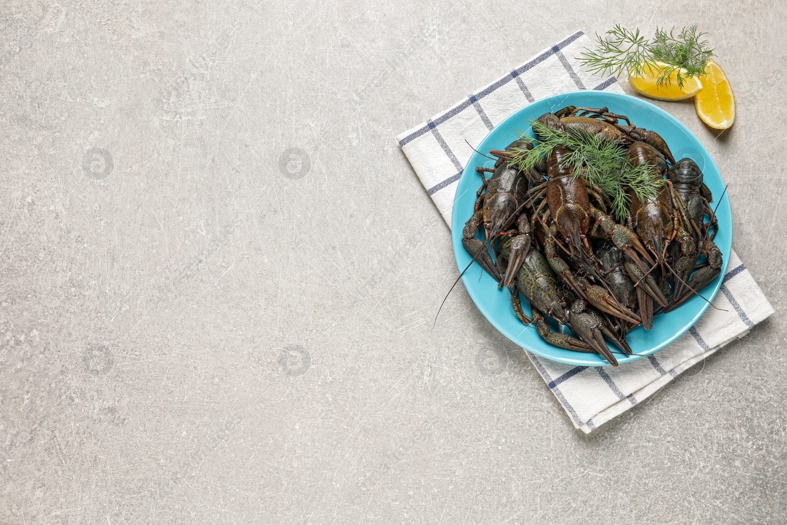 Photo of Fresh raw crayfishes with lemon and dill on light grey table, flat lay. Space for text