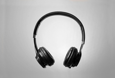 Photo of Stylish modern headphones with earmuffs on color background