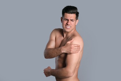 Photo of Man suffering from shoulder pain on grey background