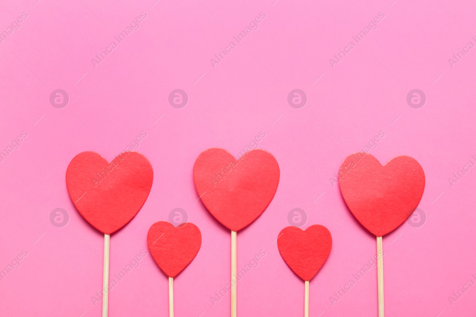 Photo of Red decorative hearts and space for text on pink background, flat lay. Valentine's Day