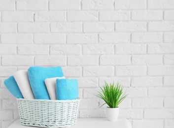 Photo of Wicker basket with clean towels in bathroom