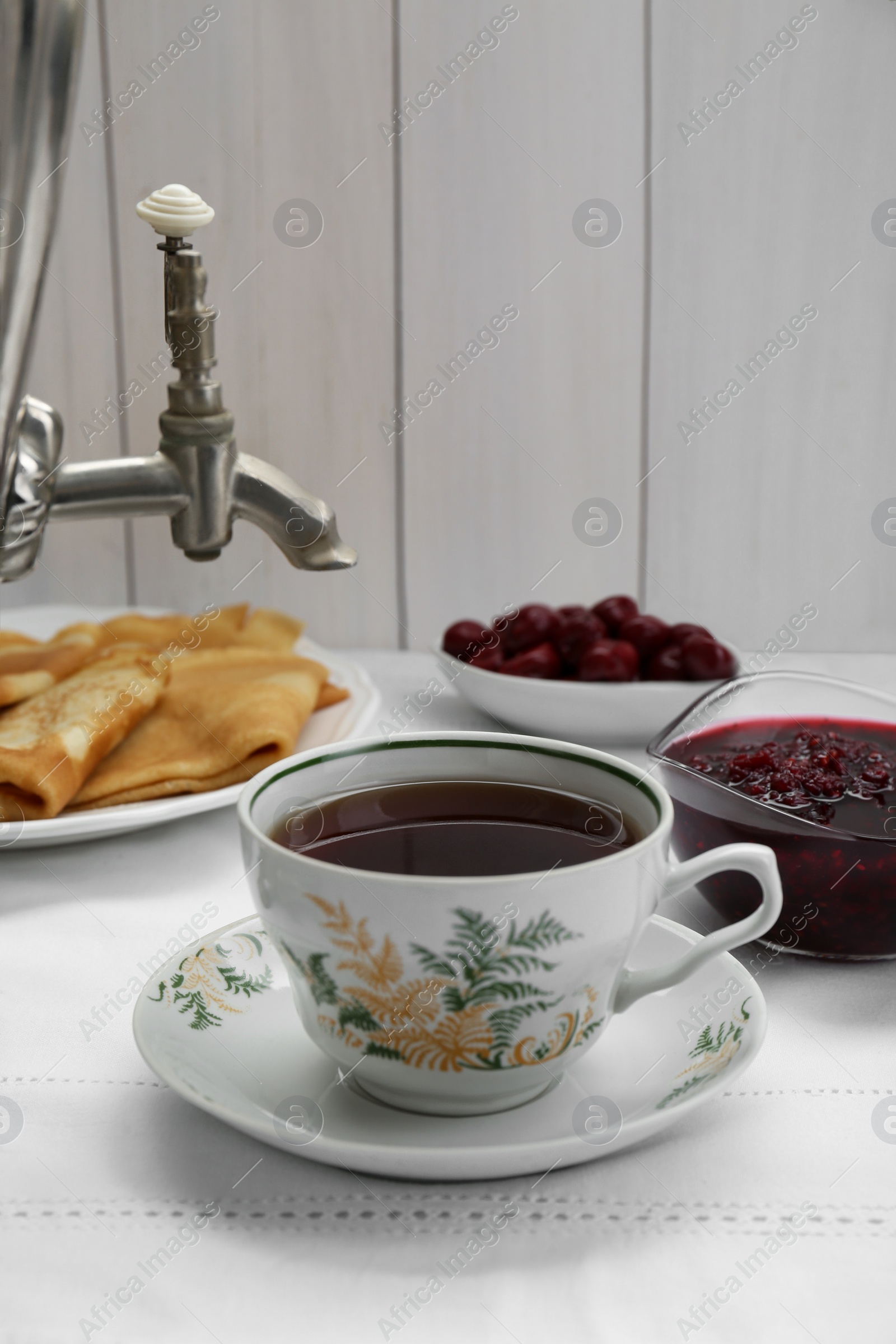 Photo of Cup of aromatic tea and treats on table