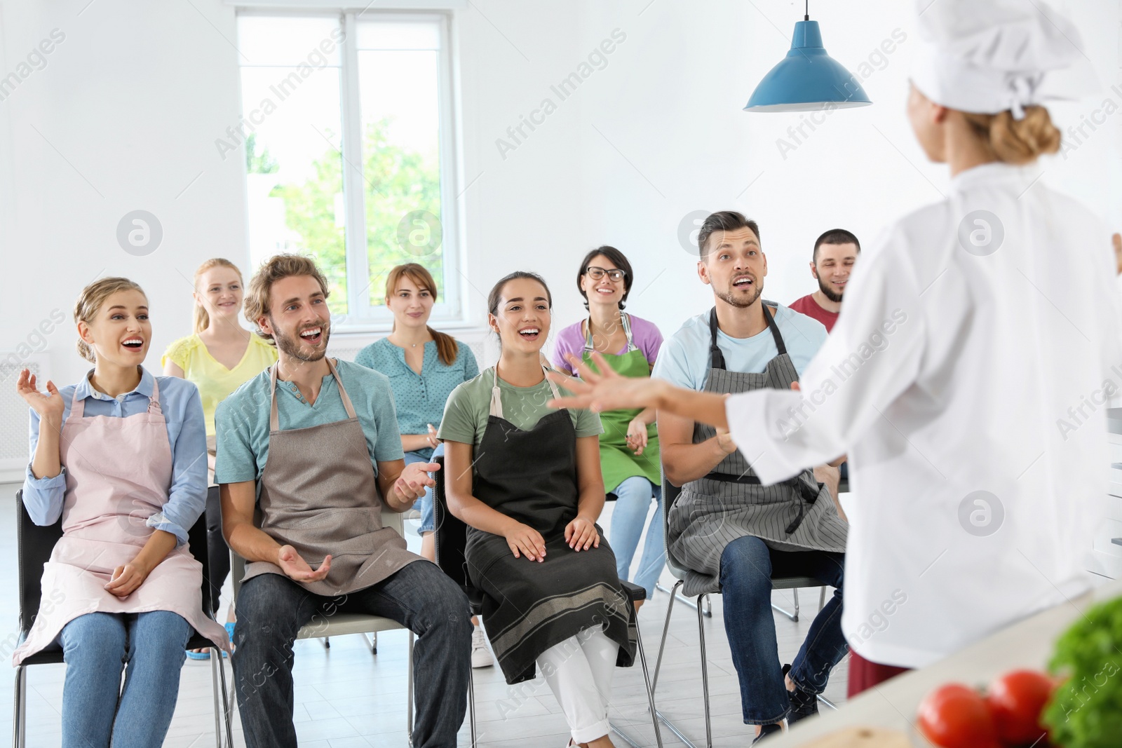 Photo of Group of people and female chef at cooking classes