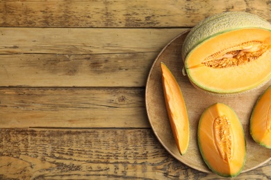 Tasty fresh cut melons on wooden table, top view. Space for text