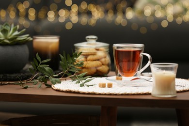 Photo of Tea, cookies and decorative elements on wooden table indoors