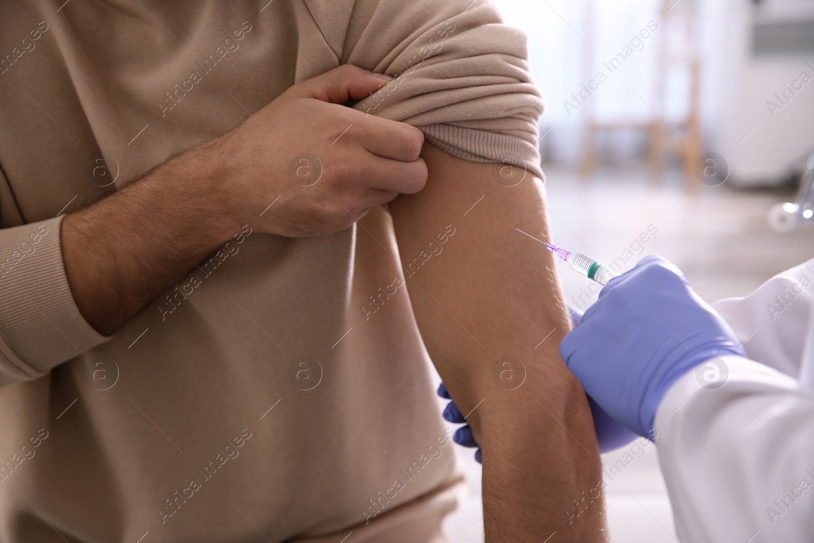 Photo of Doctor giving injection to patient in hospital, closeup. Vaccination concept