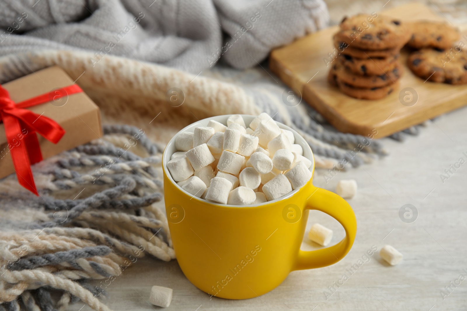 Photo of Cup of hot cocoa with marshmallows on white wooden table. Winter drink