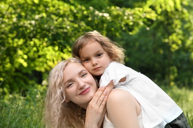 Portrait of beautiful mother with her cute daughter outdoors