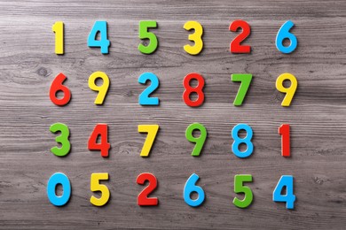 Colorful numbers on wooden school desk, flat lay