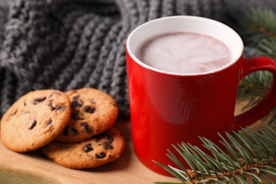 Photo of Cup of tasty cocoa and cookies on wooden board