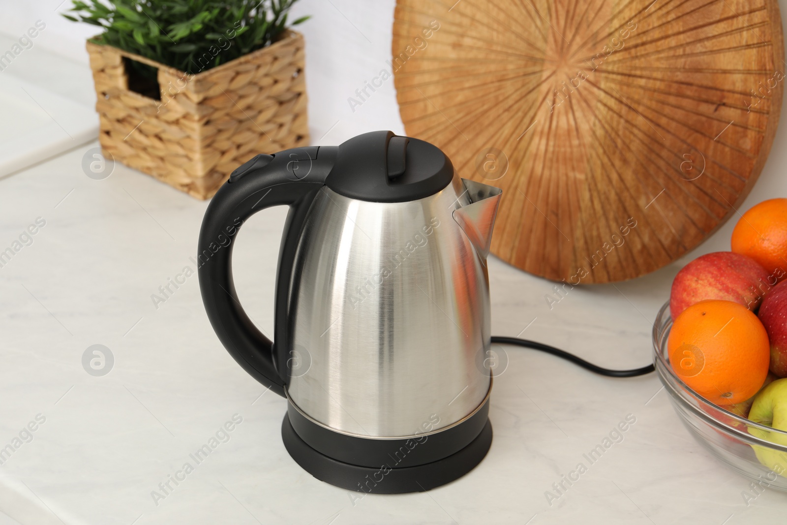 Photo of Modern electric kettle on table in kitchen