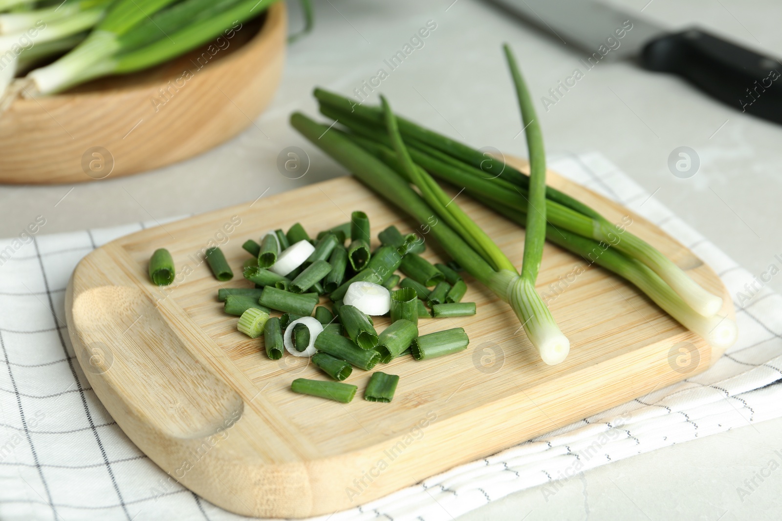 Photo of Fresh green spring onions on wooden board