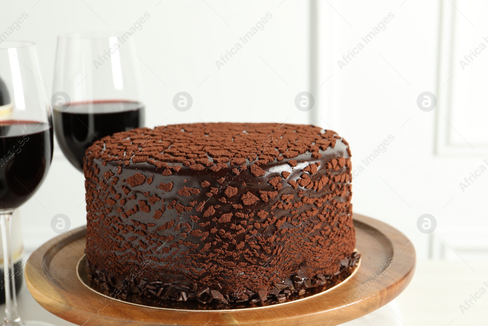 Photo of Delicious chocolate truffle cake and red wine on table