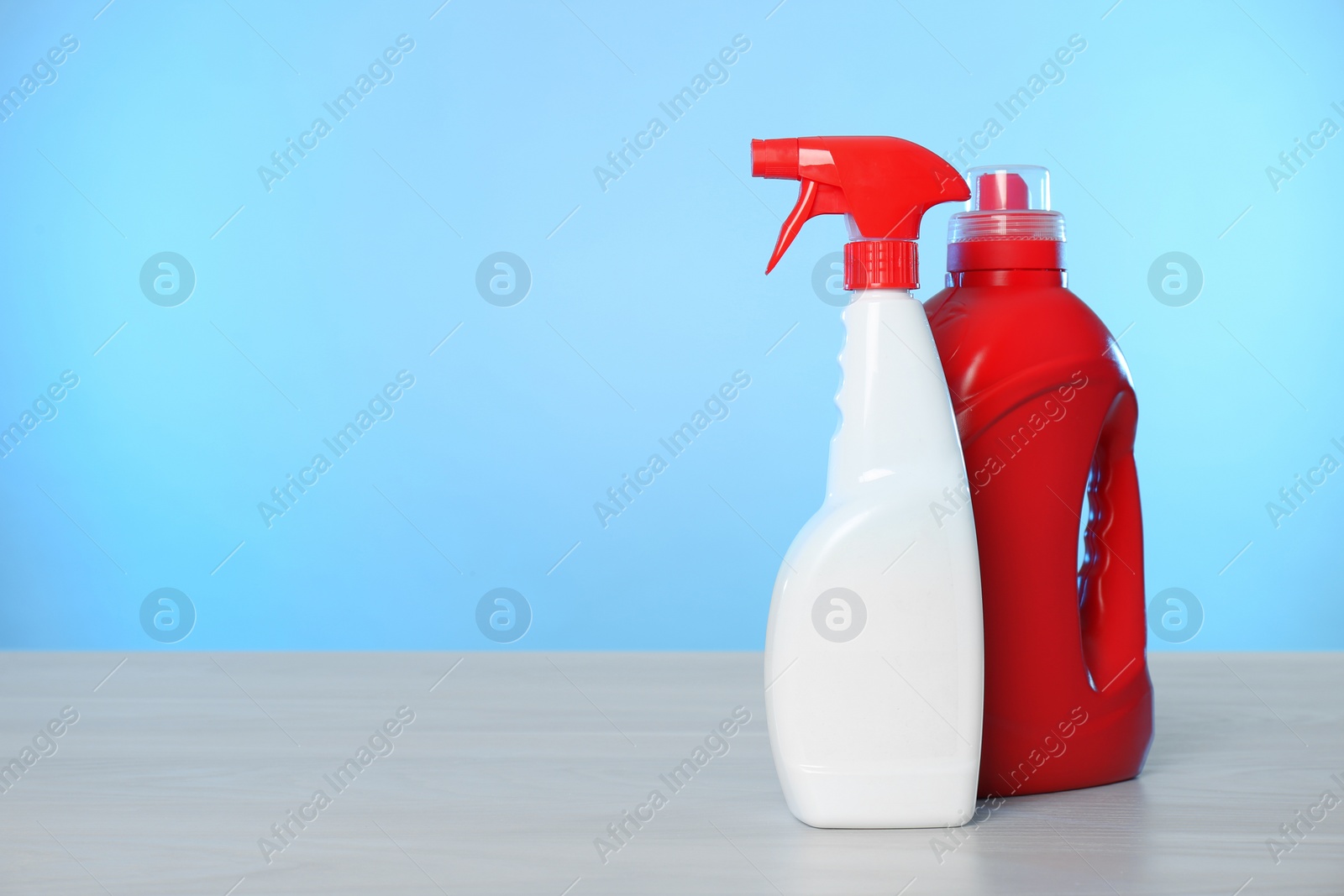 Photo of Bottles of cleaning products on light table. Space for text