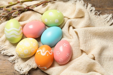 Colorful painted Easter eggs and cloth on table, space for text