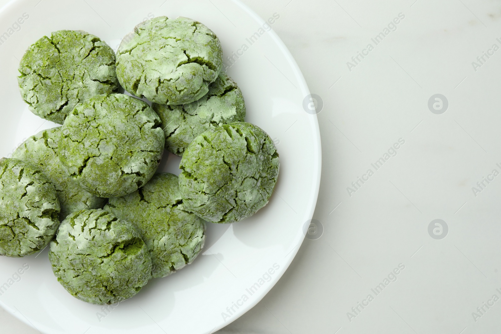 Photo of Plate with tasty matcha cookies on white table, top view. Space for text