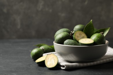 Photo of Fresh green feijoa fruits on black table, space for text