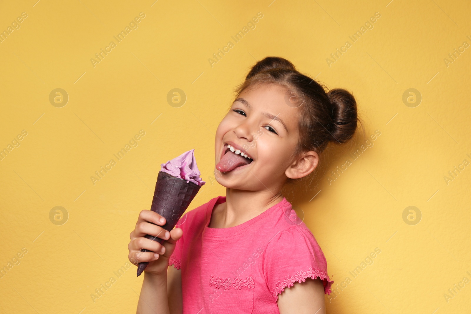 Photo of Adorable little girl with delicious ice cream against color background