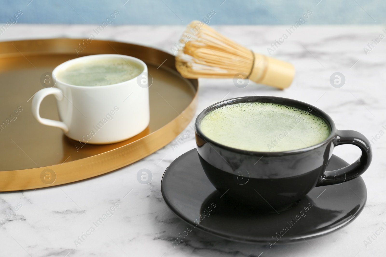 Photo of Cups of fresh matcha tea on table
