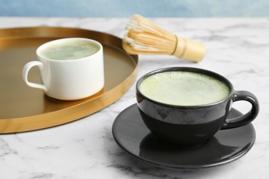 Cups of fresh matcha tea on table