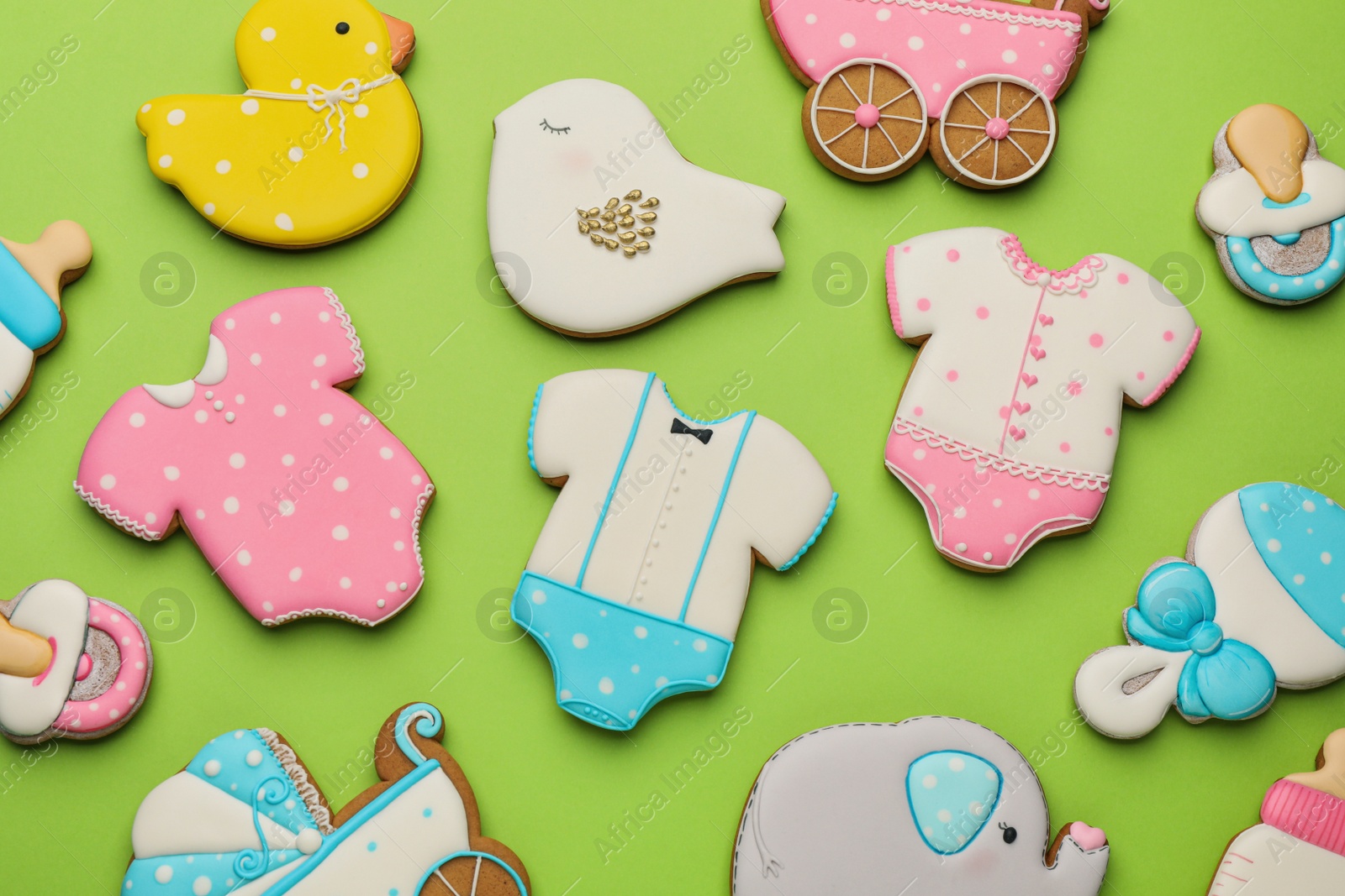 Photo of Cute tasty cookies of different shapes on light green background, flat lay. Baby shower party