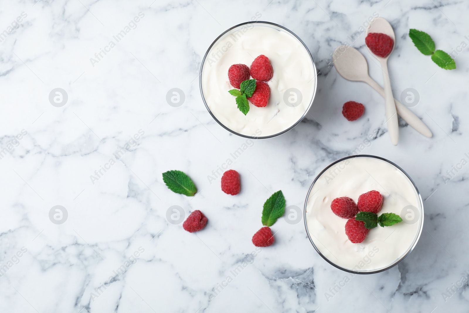 Photo of Delicious dessert with raspberries in glasses on table