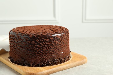 Delicious chocolate truffle cake on light grey table