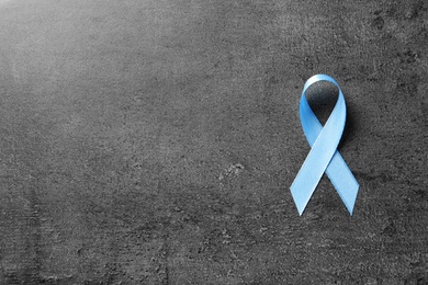 Photo of Blue ribbon on grey background, top view. Cancer awareness