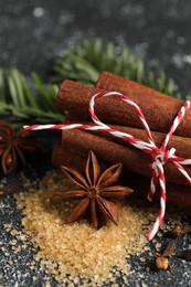 Different aromatic spices on grey textured table, closeup