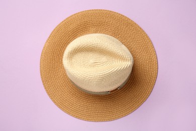 Photo of Stylish straw hat on lilac background, top view
