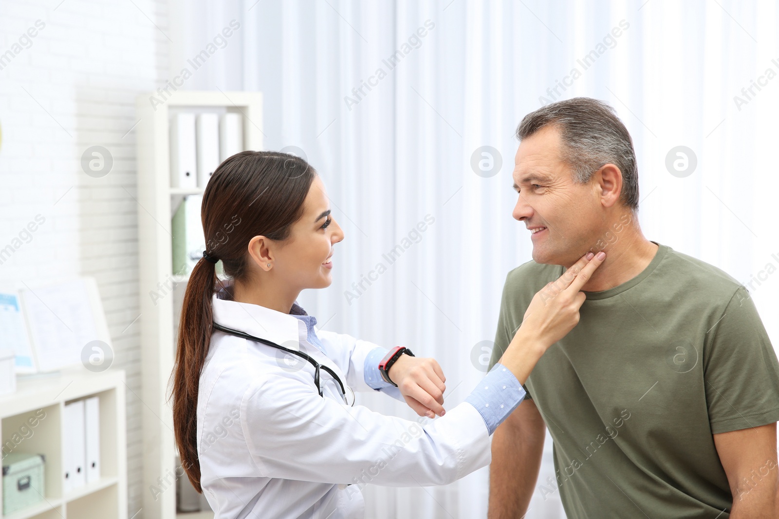 Photo of Doctor checking mature man's pulse with fingers in hospital