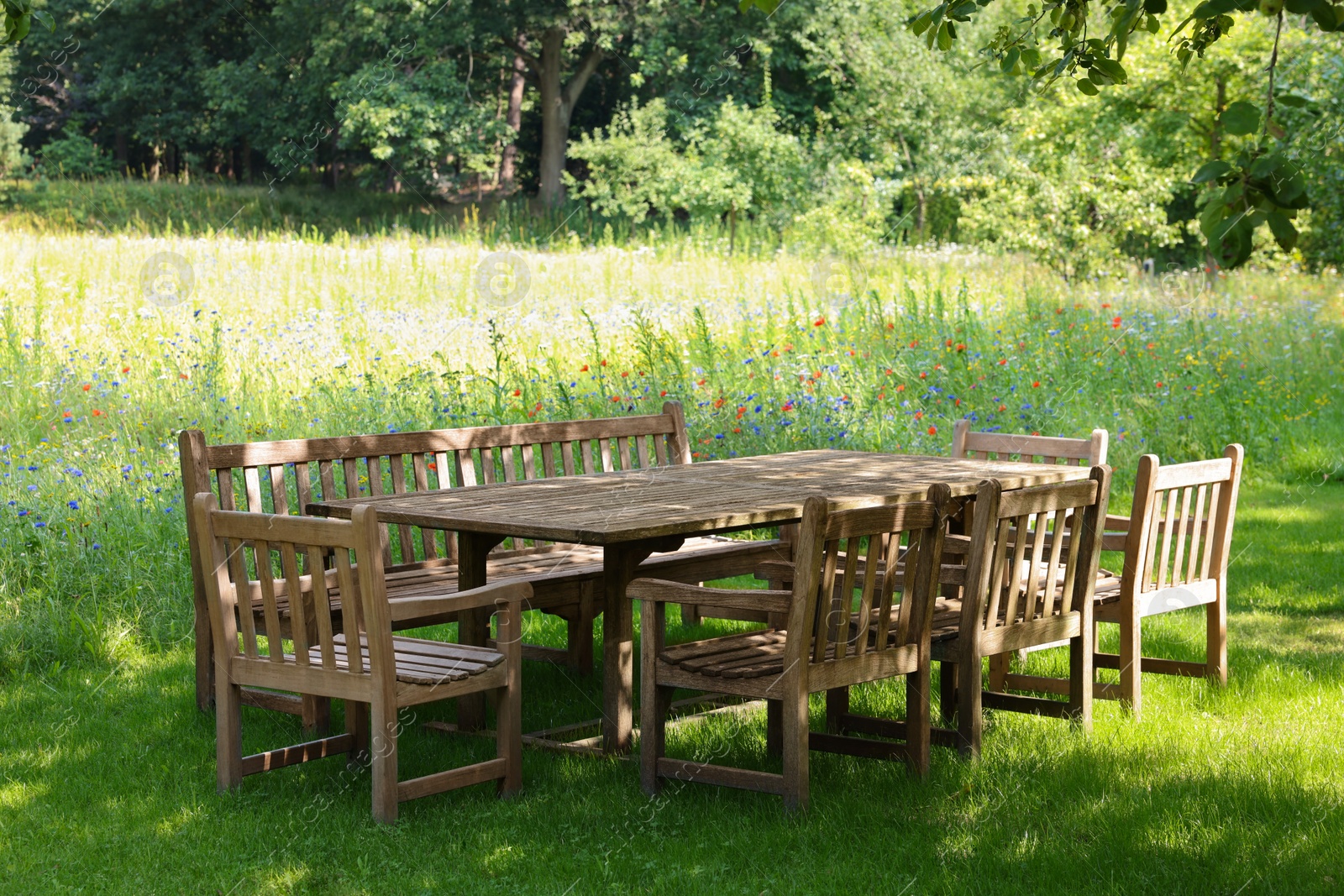 Photo of Empty wooden table with bench and chairs in garden