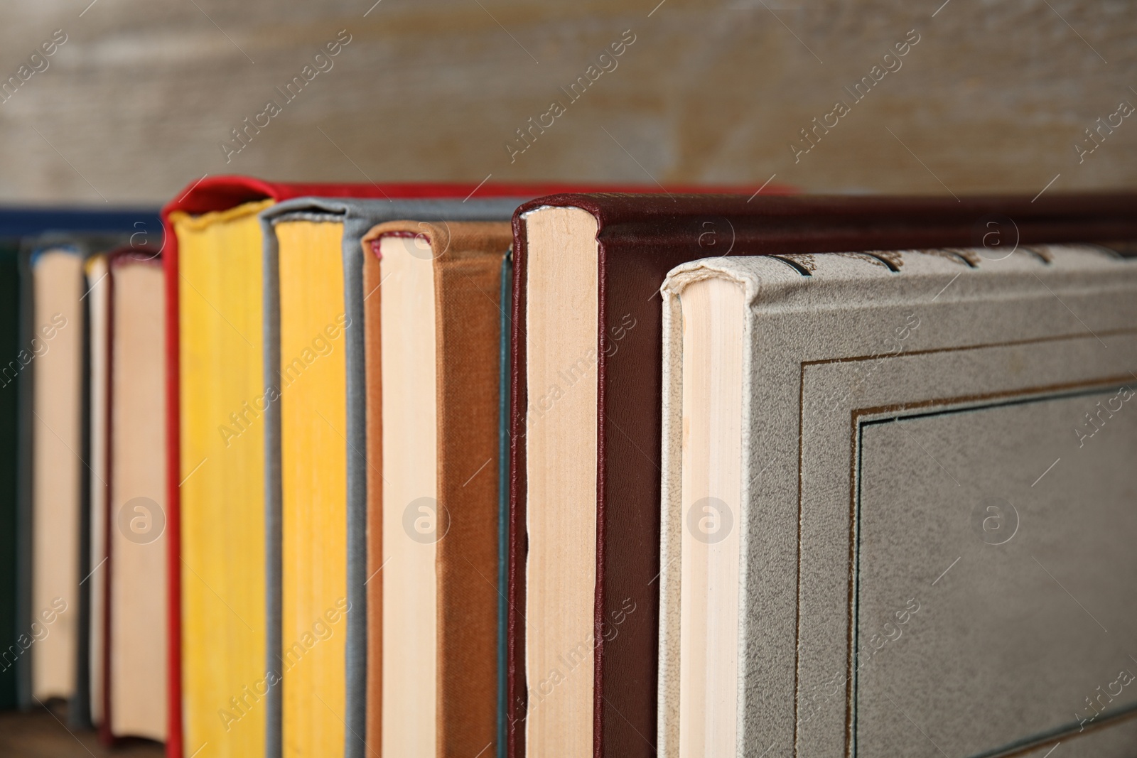 Photo of Stack of hardcover books on wooden background, closeup