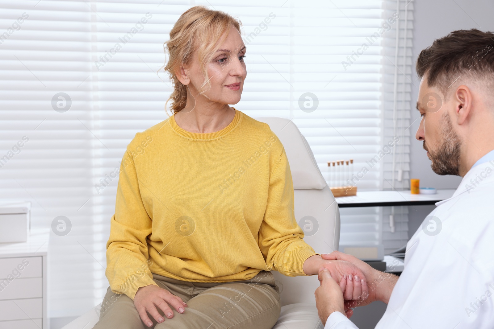 Photo of Doctor checking patient's pulse during consultation in clinic