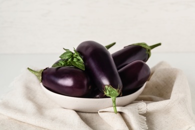 Photo of Ripe purple eggplants and basil on table
