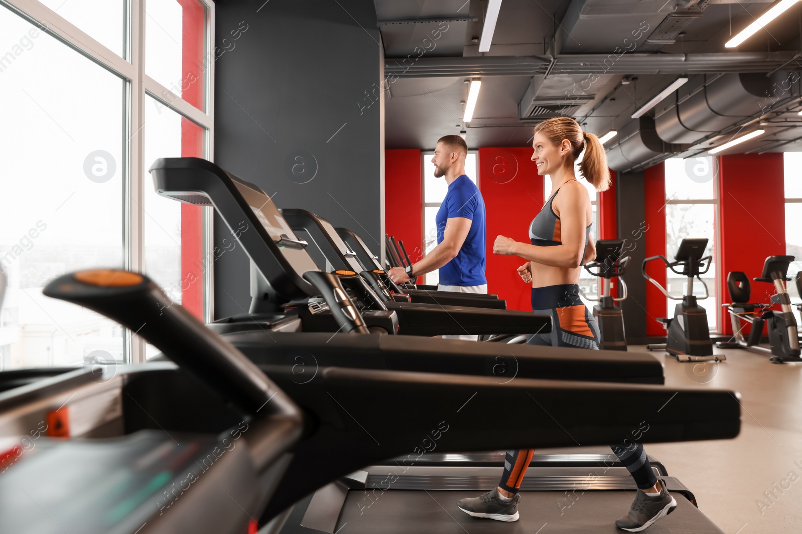 Photo of Beautiful couple training on treadmills in gym