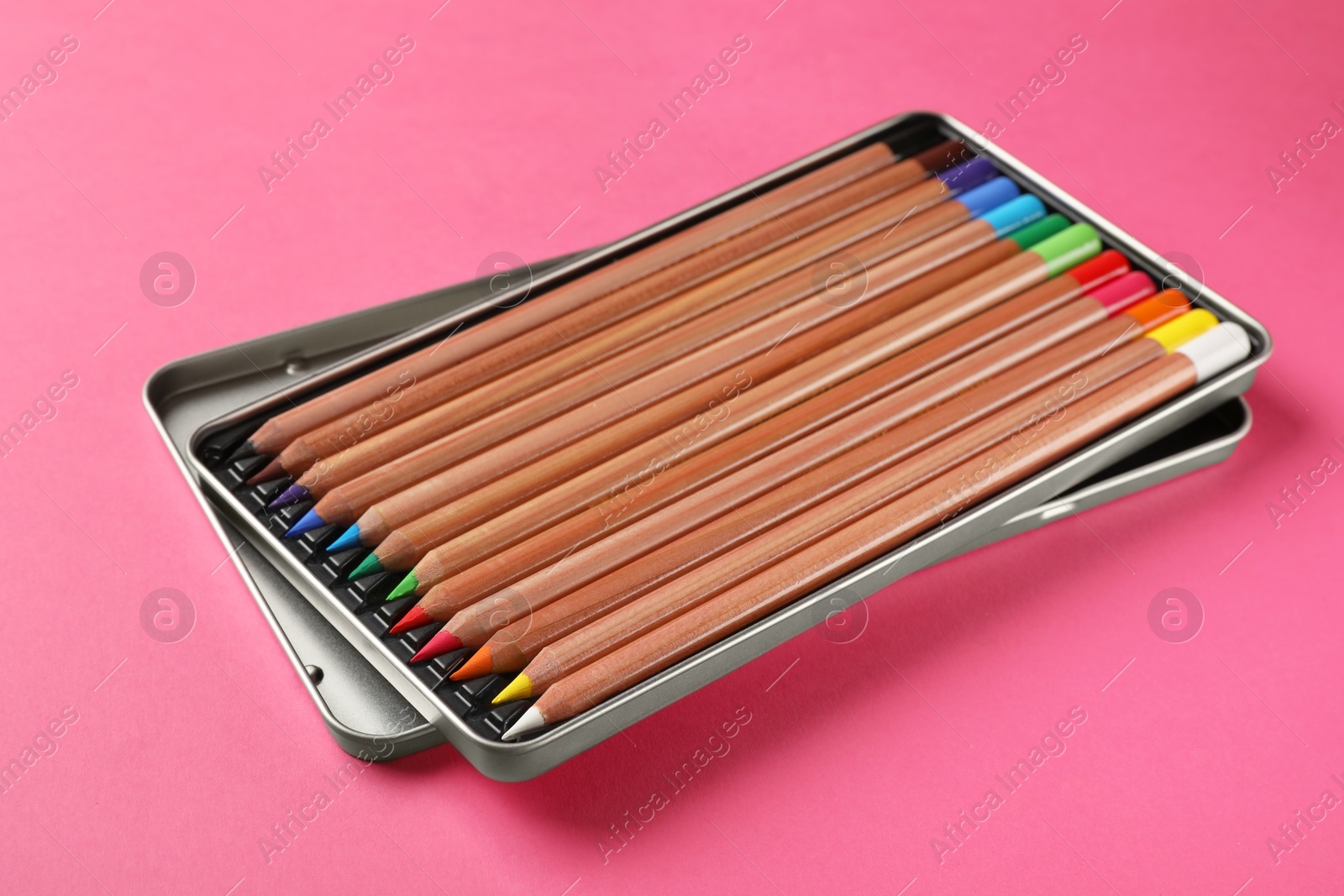 Photo of Box with many colorful pastel pencils on pink background. Drawing supplies