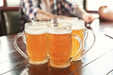 Photo of Glasses of tasty beer on table indoors
