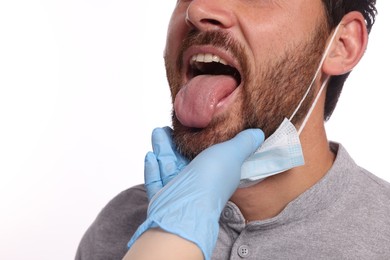 Doctor examining man`s oral cavity on white background, closeup